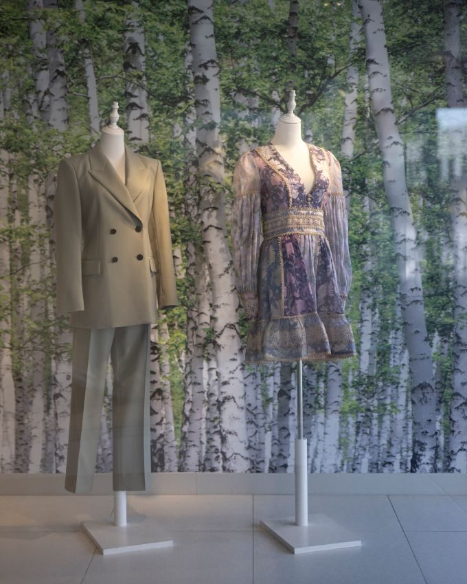Two mannequins in a sage suit and a floral mini dress in the VENLA Mosman window