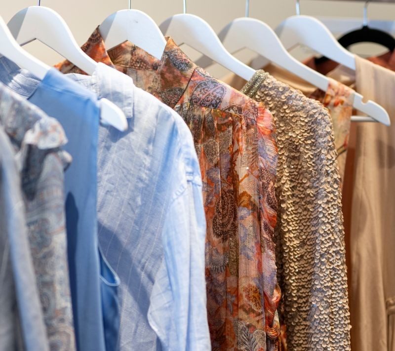 Preloved blouses and dresses on white hangers at VENLA