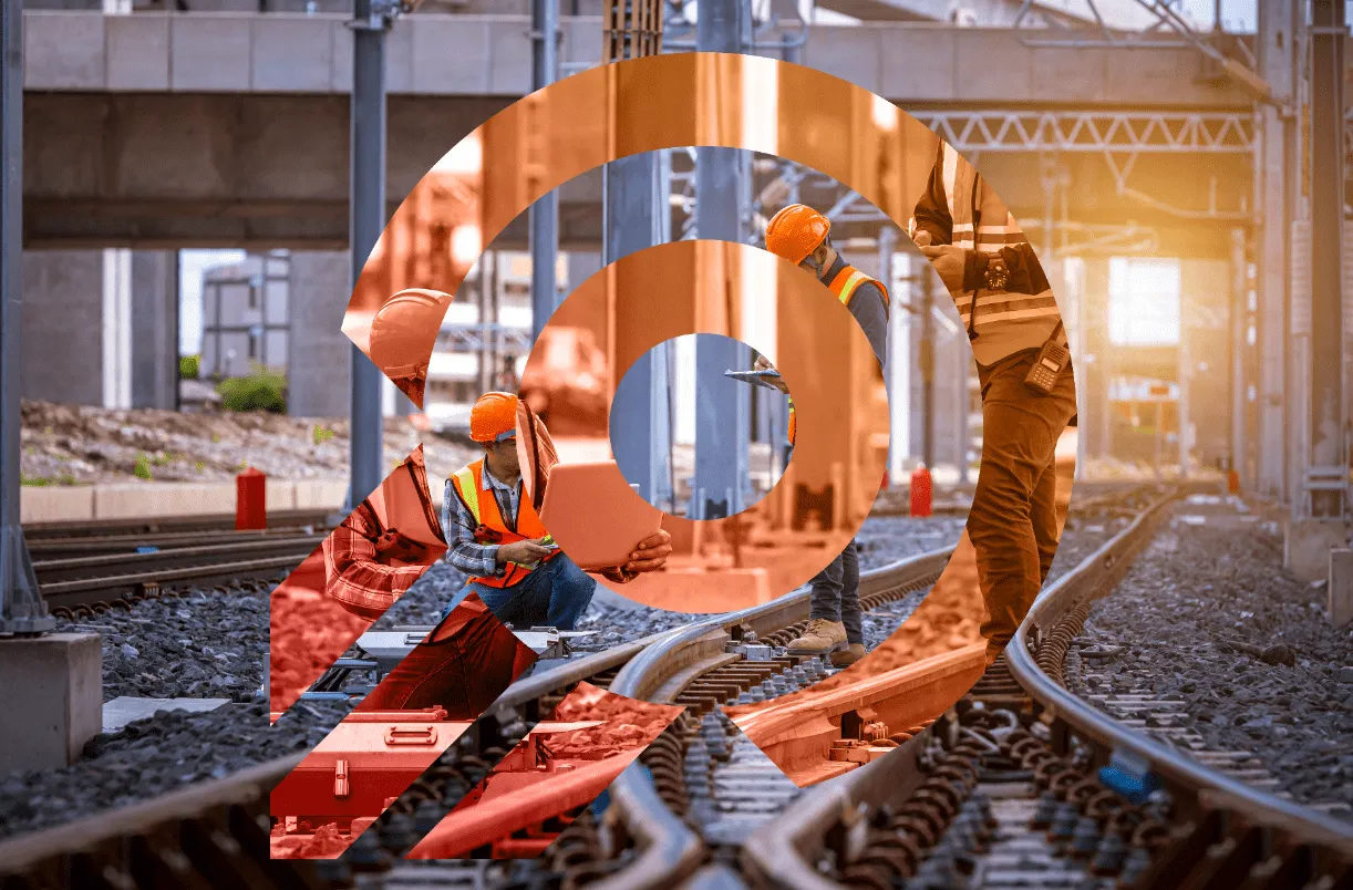 Three construction workers wearing safety vests and helmets inspecting railway tracks at a train yard with a semi-transparent wifi symbol overlay.