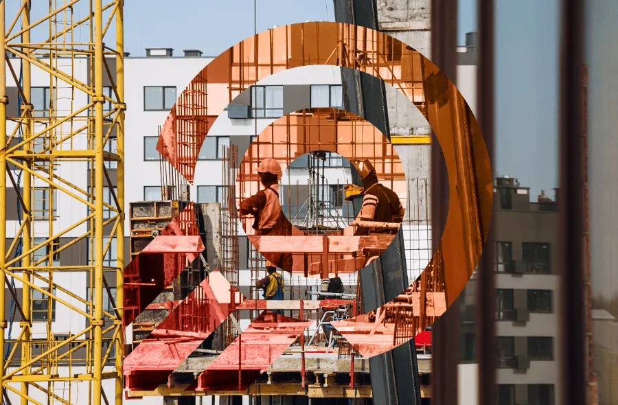 Construction workers wearing helmets working on a building site with scaffolding and high-rise buildings in the background.