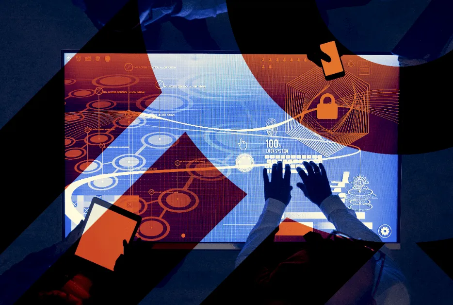 Overhead view of two people interacting with a large digital touchscreen displaying a complex lock system interface and security graphics.
