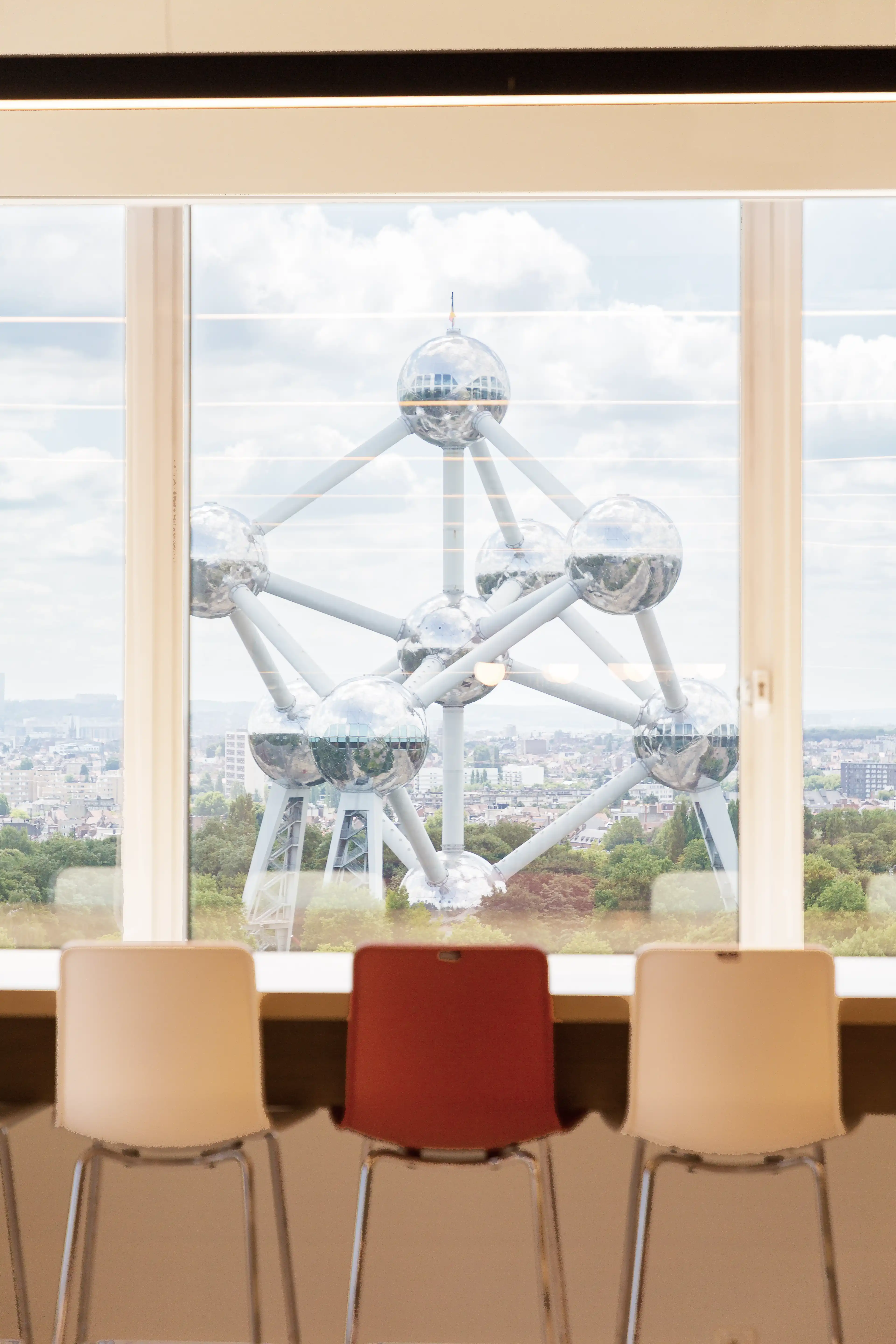 Espace communautaire avec sièges donnant sur l'Atomium dans les bureaux de Henkel à Bruxelles, rénové par Space Refinery