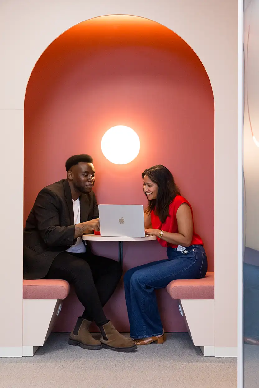 Deux personnes collaborent dans une cabine de réunion dans les bureaux de Henkel à Bruxelles, rénovés par Space Refinery.