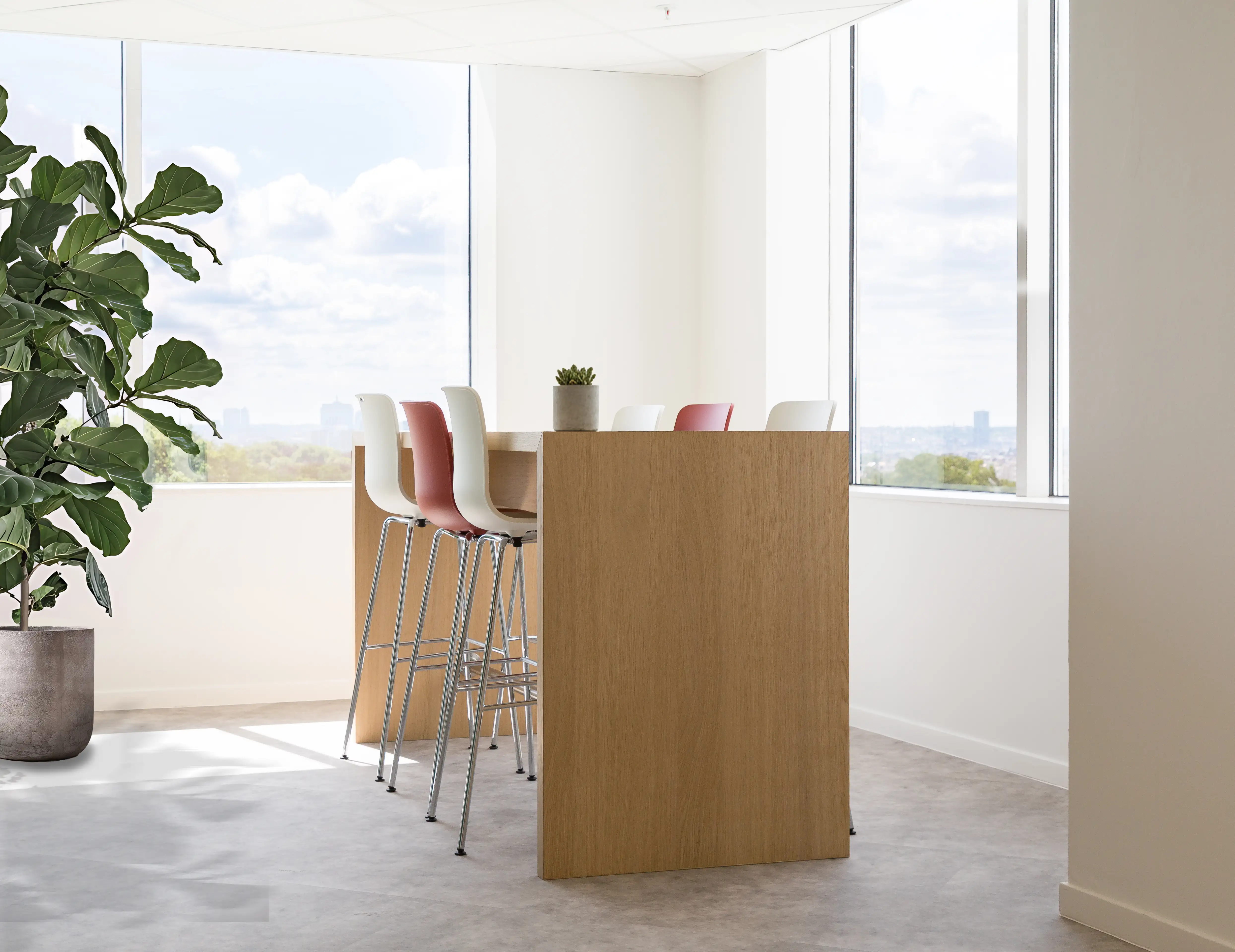 Coin de collaboration avec chaises hautes et table dans les bureaux de Henkel à Bruxelles, rénovés par Space Refinery