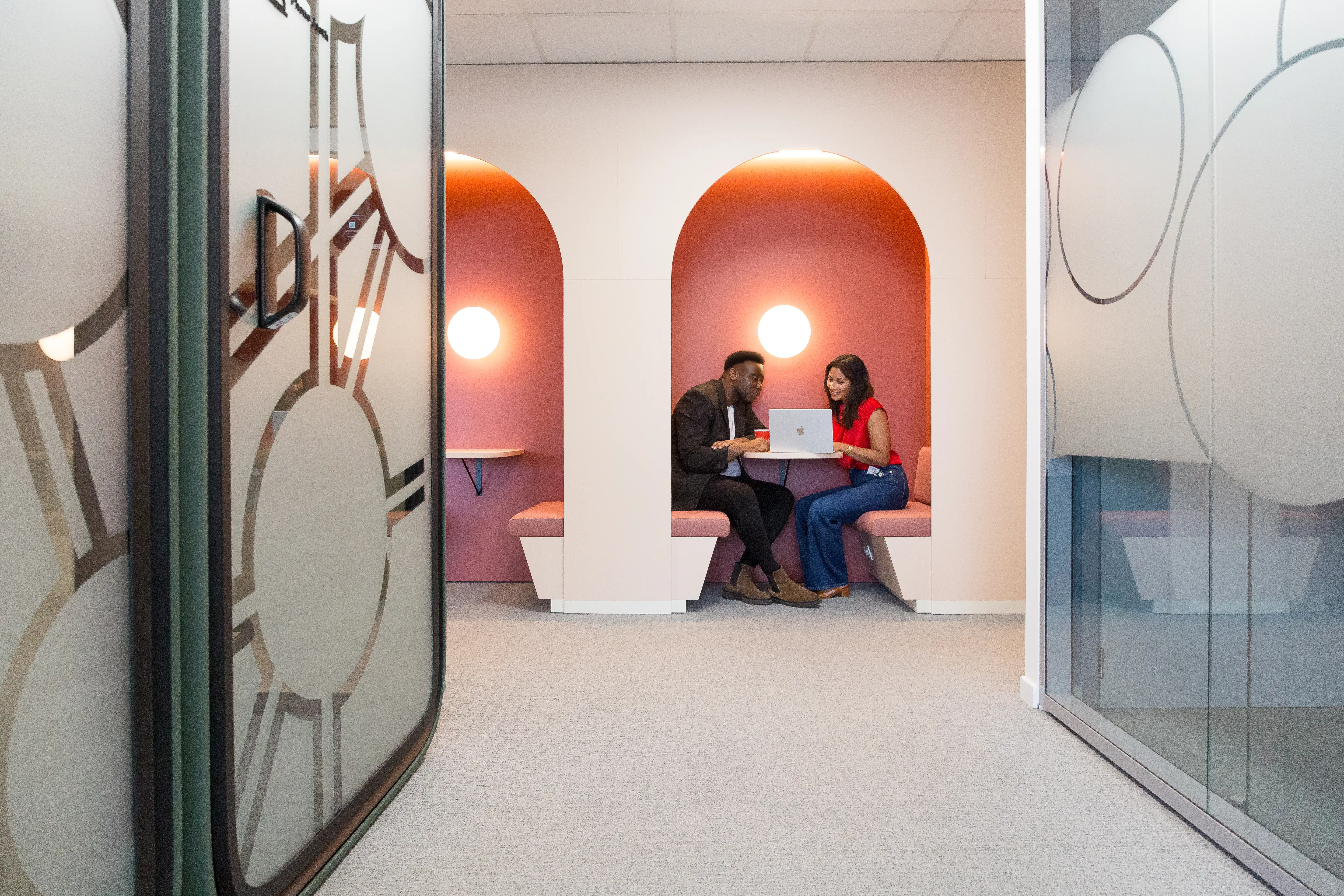 Deux personnes dans une cabine de réunion dans les bureaux de Henkel à Bruxelles rénovés par Space Refinery