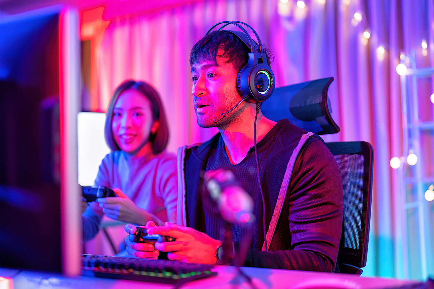 Two people gaming on a computer to represent online gaming payment gateways