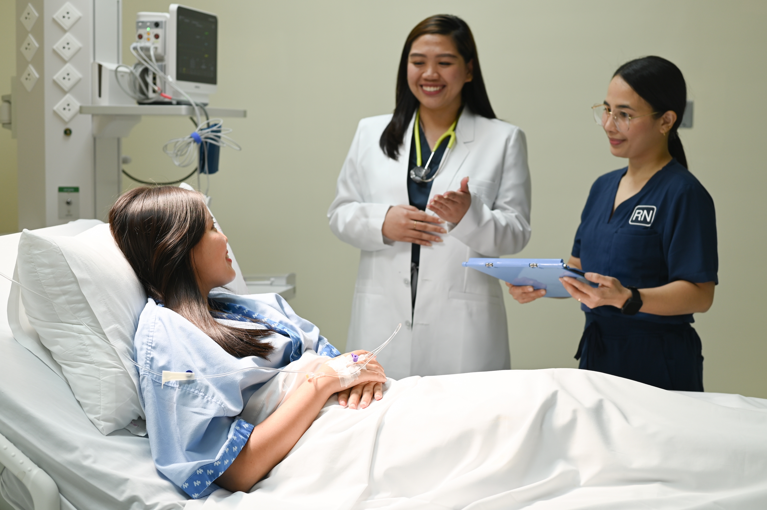 An HMO patient in hospital bed assisted by a doctor and a nurse