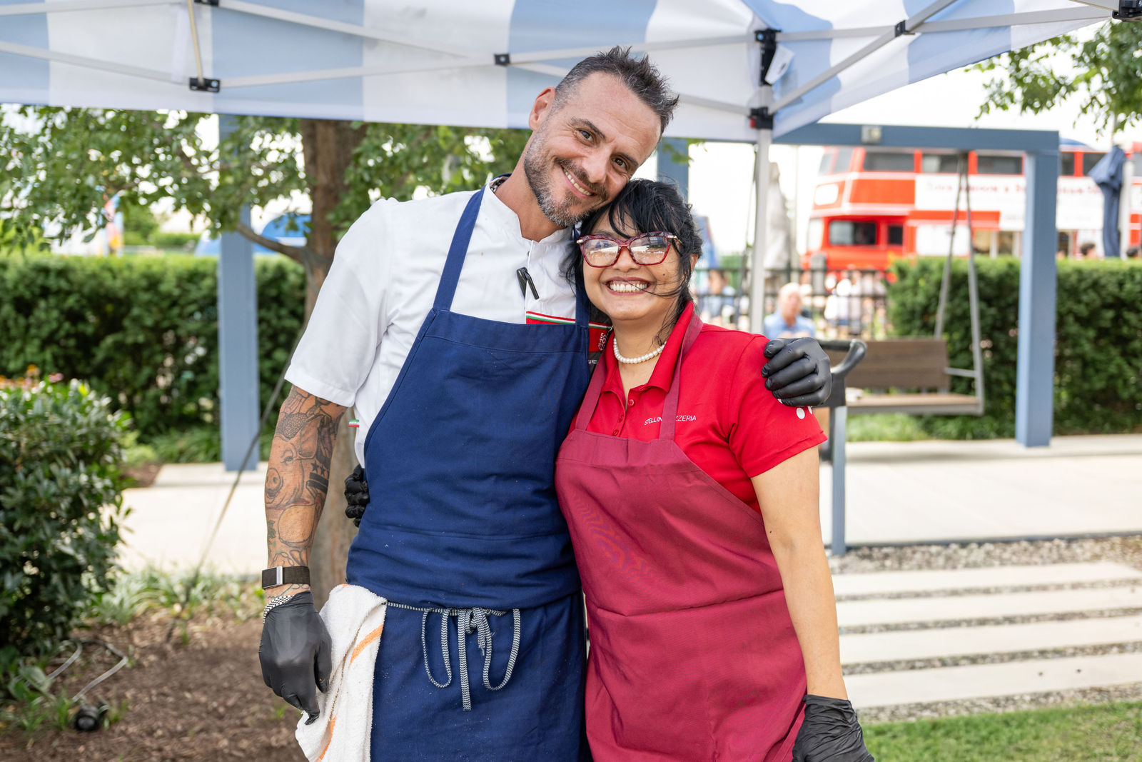 Two chefs in aprons posing together and smiling outdoors at Capital One Center Culinary Week 2026