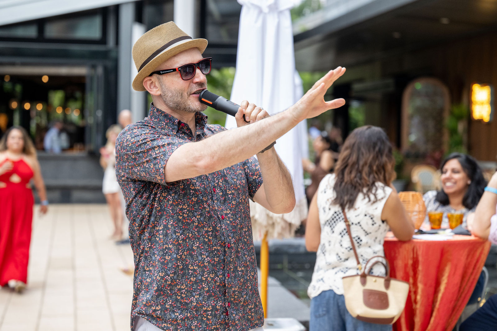 Rick, event emcee, speaking into a microphone on the outdoor patio at Capital One Center Culinary Week 2026