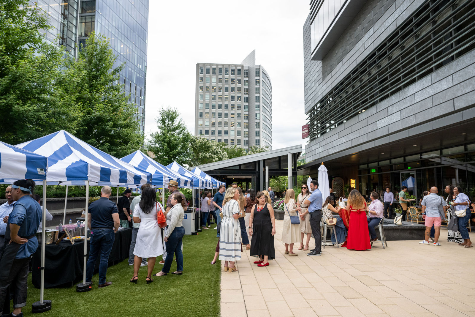 Crowd of guests mingling at outdoor restaurant booths along the Capital One Center plaza at Culinary Week 2026