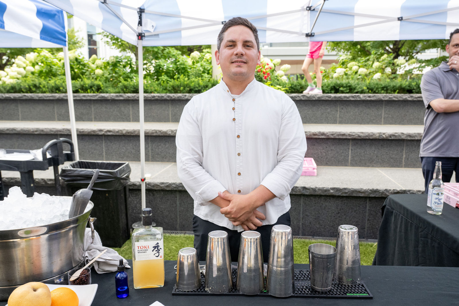 Bartender at The Naisho Room standing at a cocktail station with Toki whisky and shakers at Capital One Center Culinary Week 2026