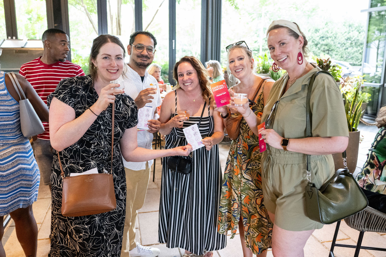 Attendees holding Cocktail Contest passports and drinks at an indoor venue at Capital One Center Culinary Week 2026