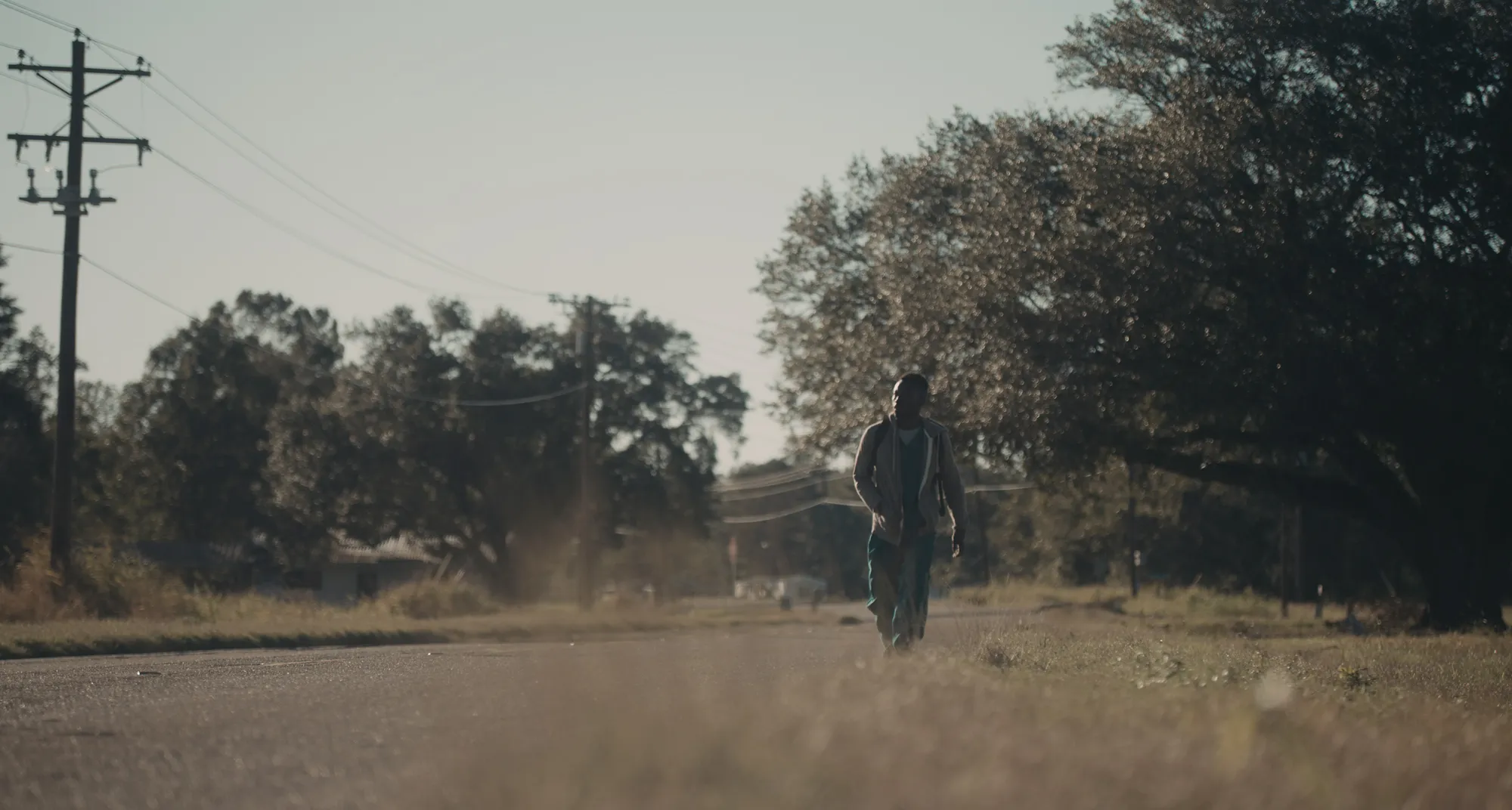 17 Year Locust film still showing the young Haitian man Renee walking beside a rural road. 
