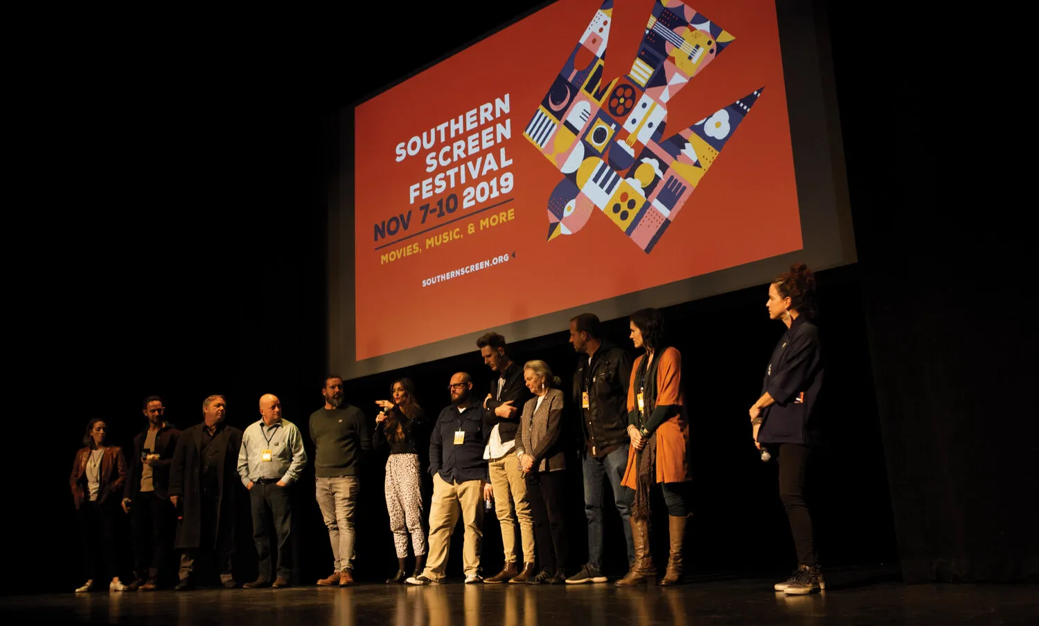Southern Screen photo showing group of people on stage speaking with Southern Screen design shown on projector
