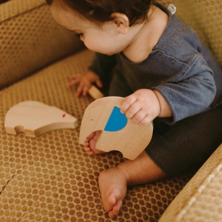 child playing with makemade animal wooden toy