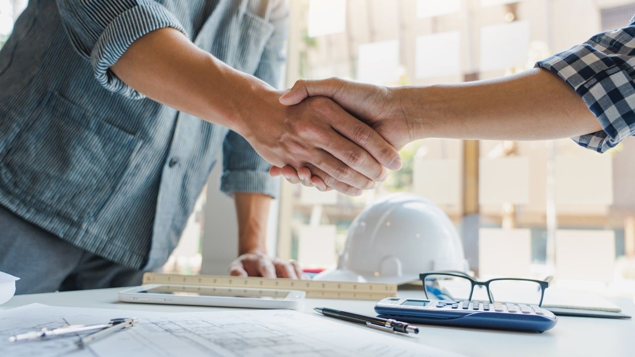 men shaking hands over table