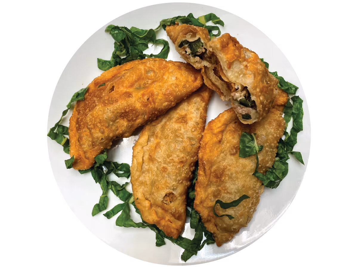 Plato blanco con empanadas y lechuga