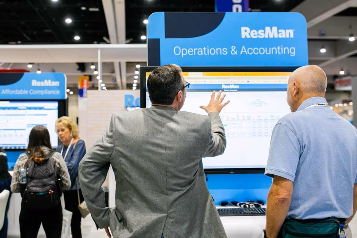 ResMan employee showing a demo at the NAA trade show booth