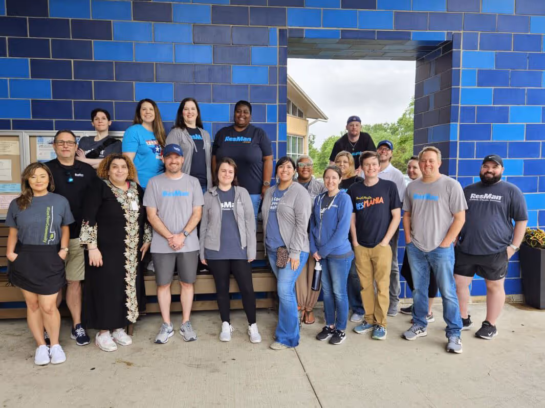 ResMan team members in front of a blue wall