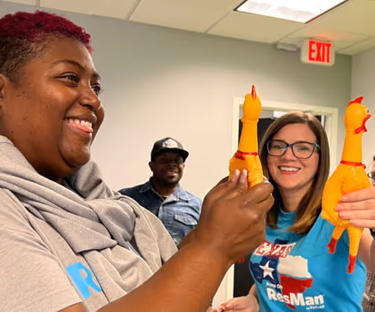 Two ResMan employees holding up rubber chickens