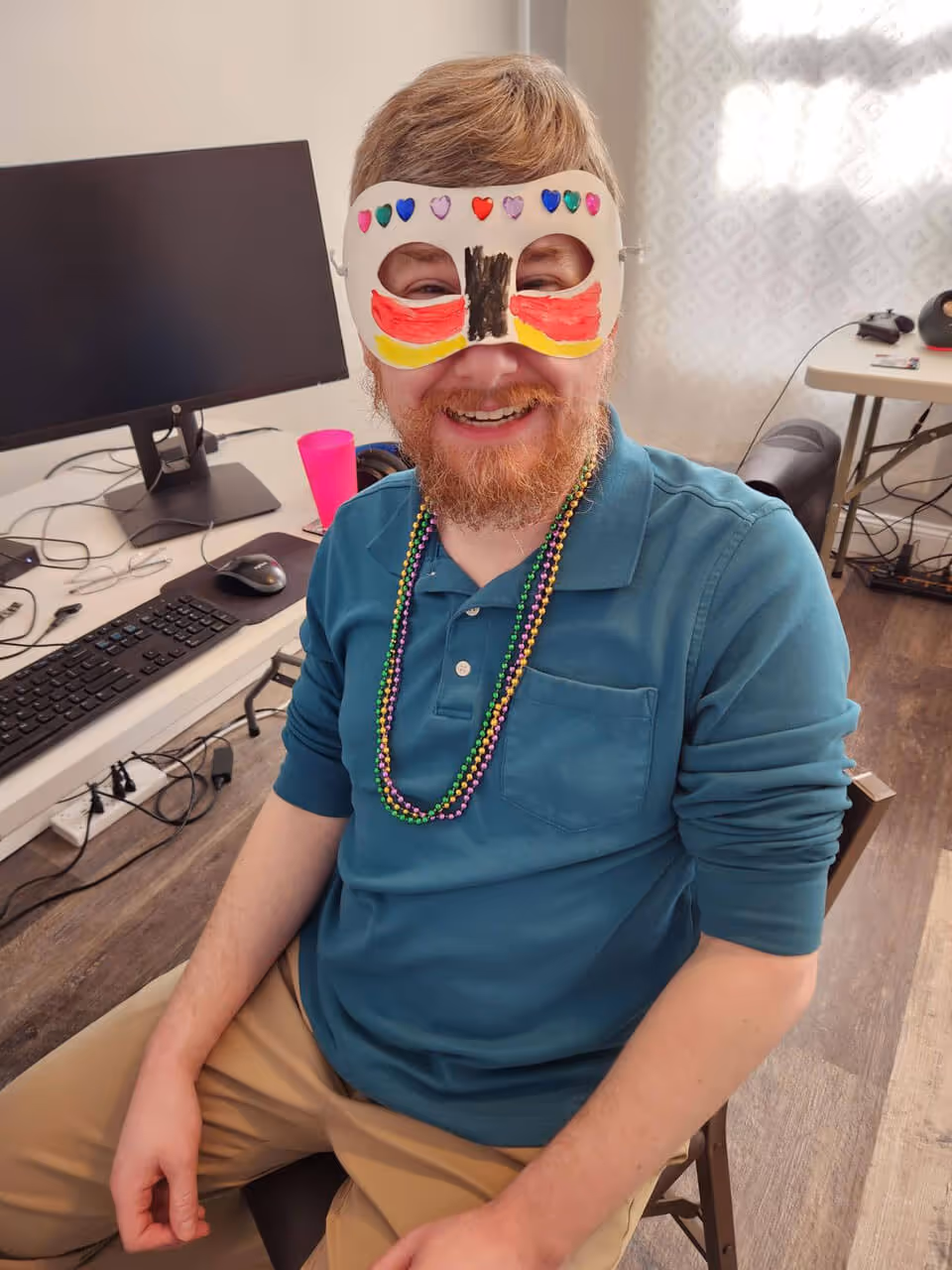 A ResMan employee wearing a Mardi Gras mask