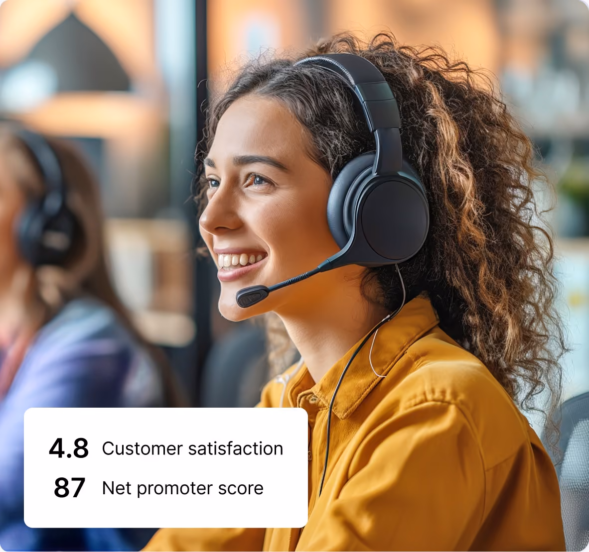 Smiling woman with curly hair wearing headset in customer service with scores 4.8 satisfaction, 87 promoter.