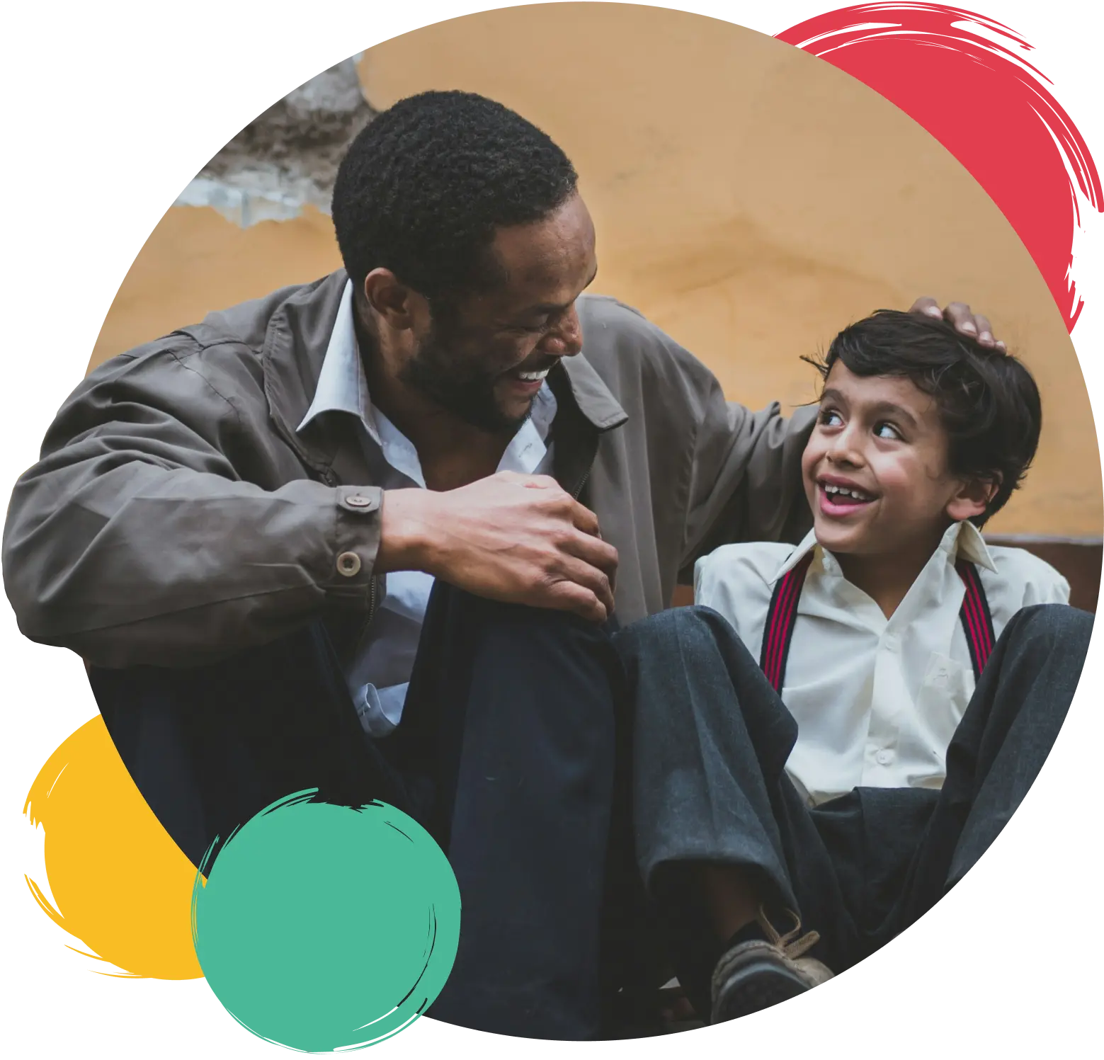 a man and his child sitting next to each other smiling and laughing