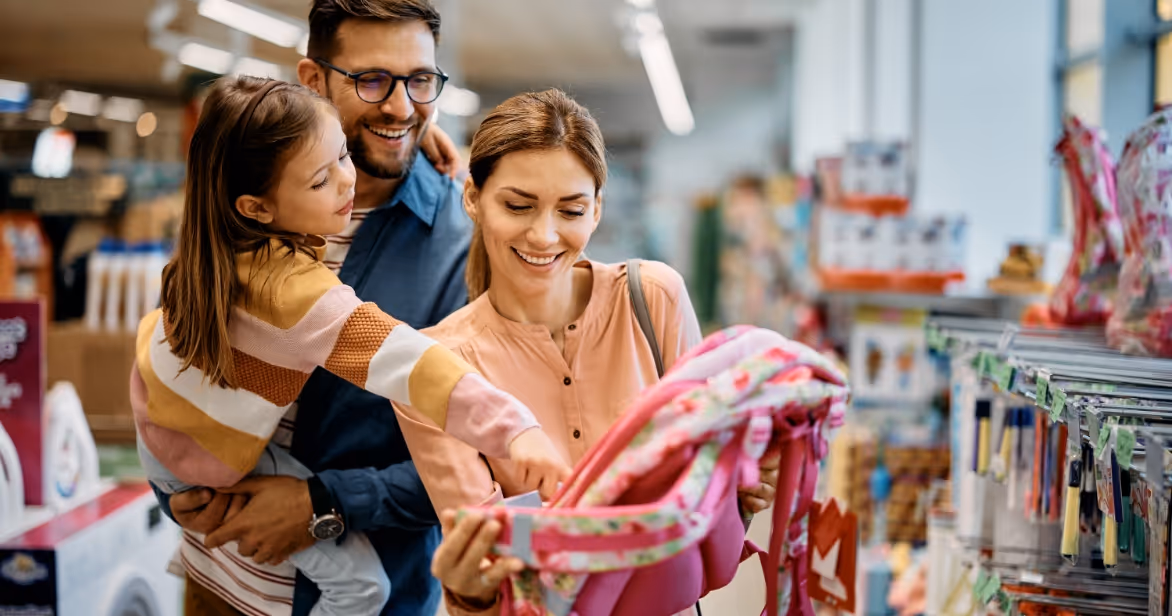 Happy family shopping for school supplies together – back-to-school fostering info session August 13th.