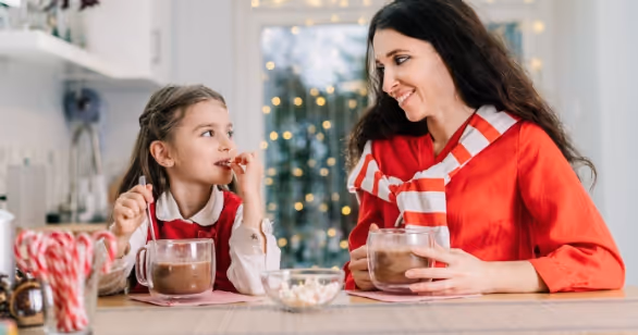 Adult and child sharing hot chocolate together at Christmas, reflecting connection and calm when navigating Christmas in foster care