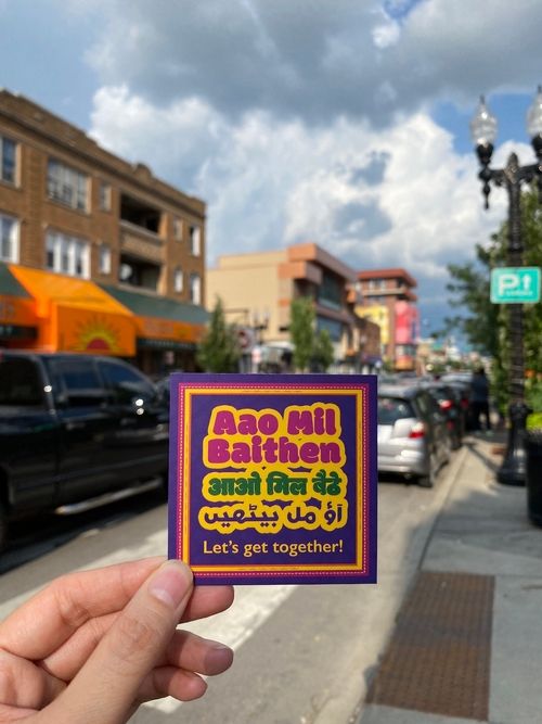 An image of a card that says "Aao Mil Baithen".