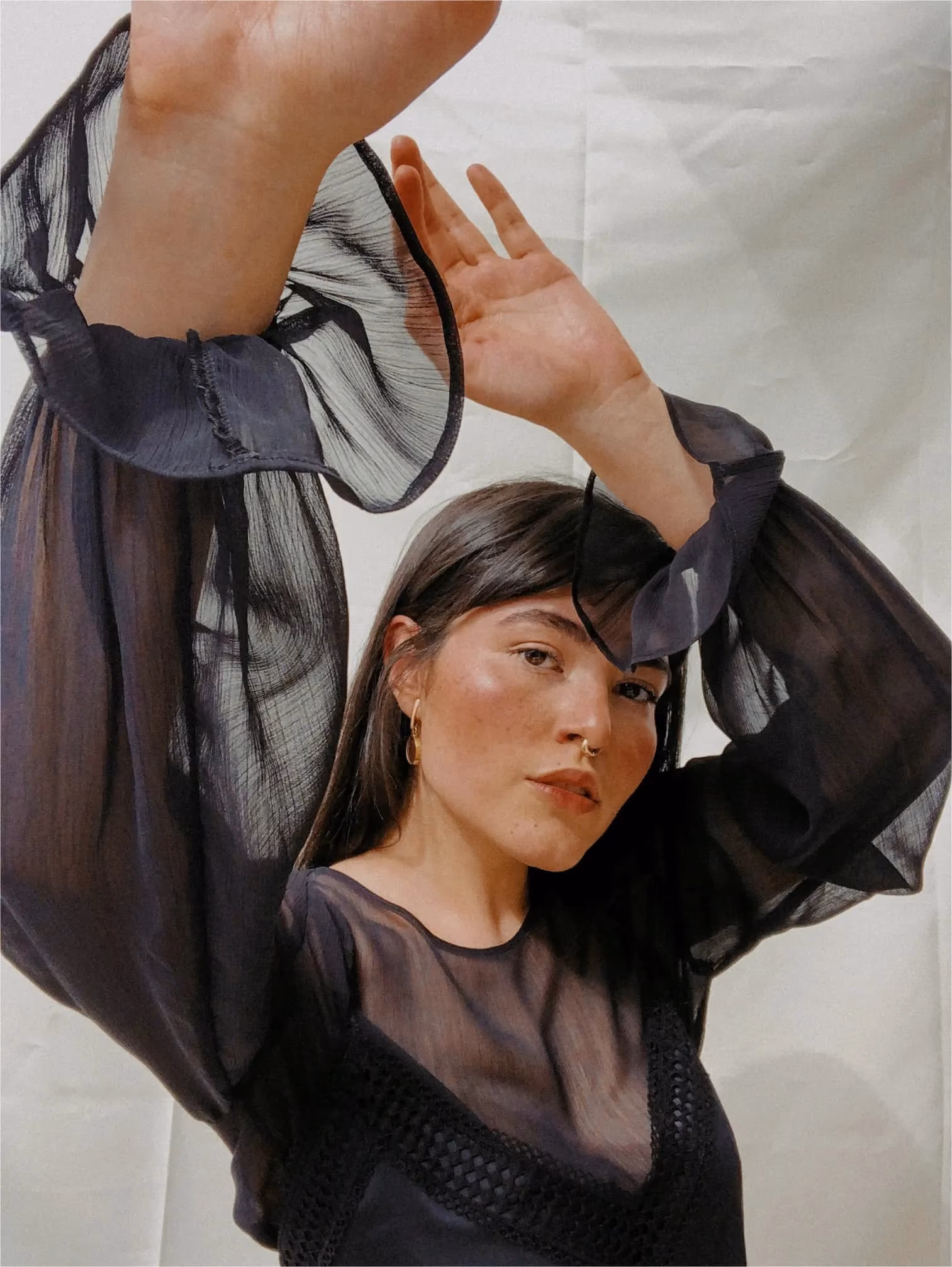 Woman in black dress with her hands up