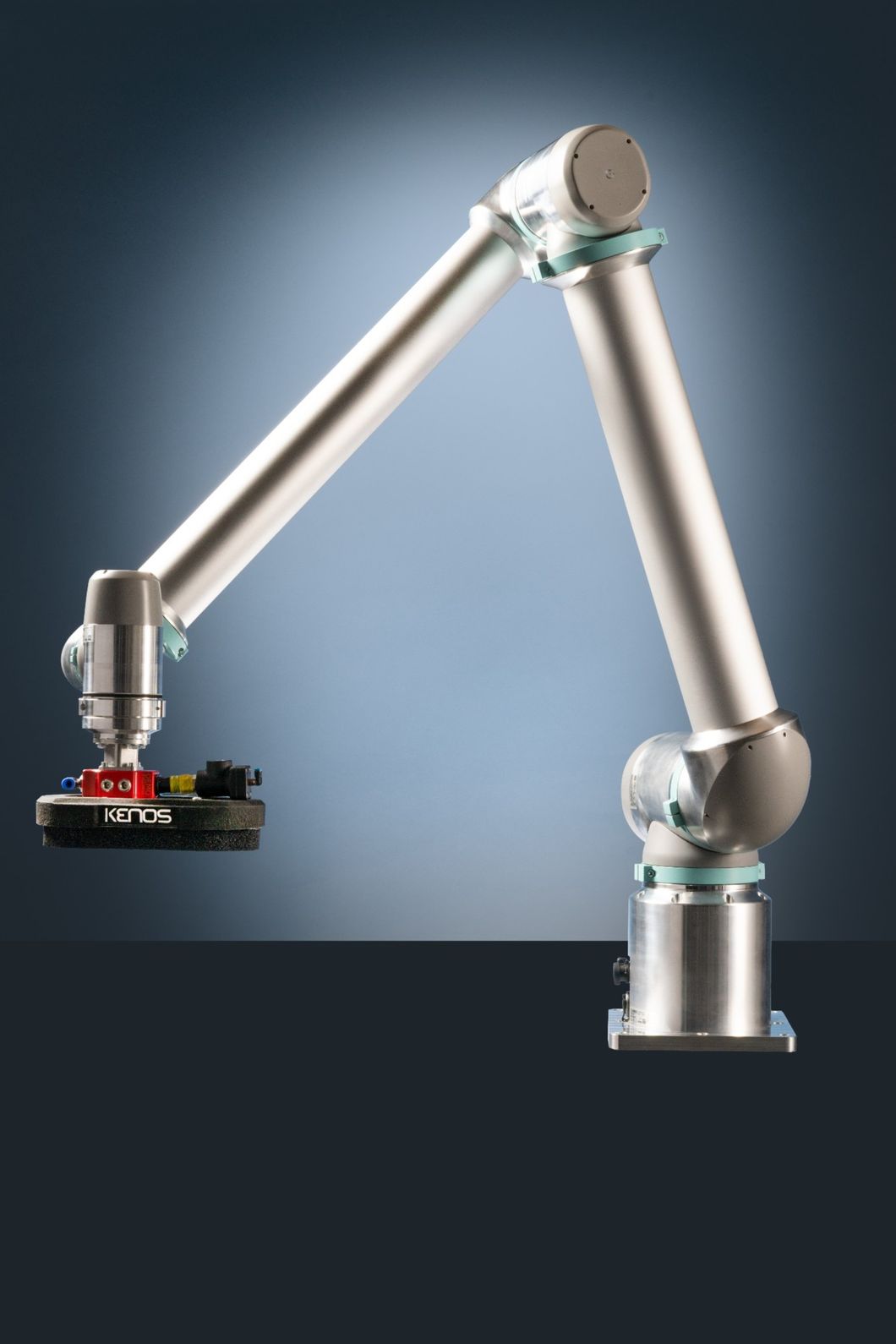 Ein moderner, silberner Roboterarm mit Vakuumgreifer auf dunklem Hintergrund als Beispiel für einen Meilenstein in der Geschichte der Robotik.
