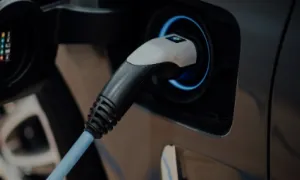 Close-up of an electric vehicle charging plug connected to the car's charging port.