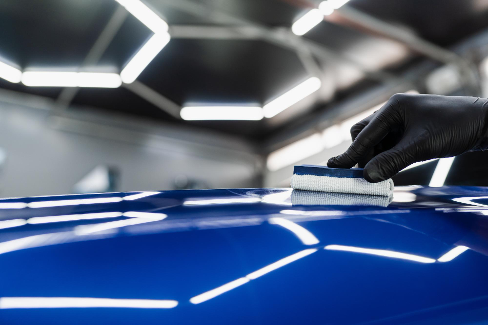 Hand applying of nano ceramic protective coat to protect car from scratches process of apply ceramic layer on body car using sponge closeup in detailing auto service