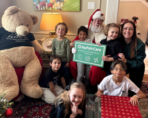 Group of children with a large teddy bear and santa clause posing for a picture at a charity event. 