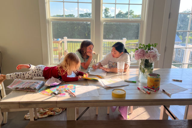 au pair helping kids with worksheets