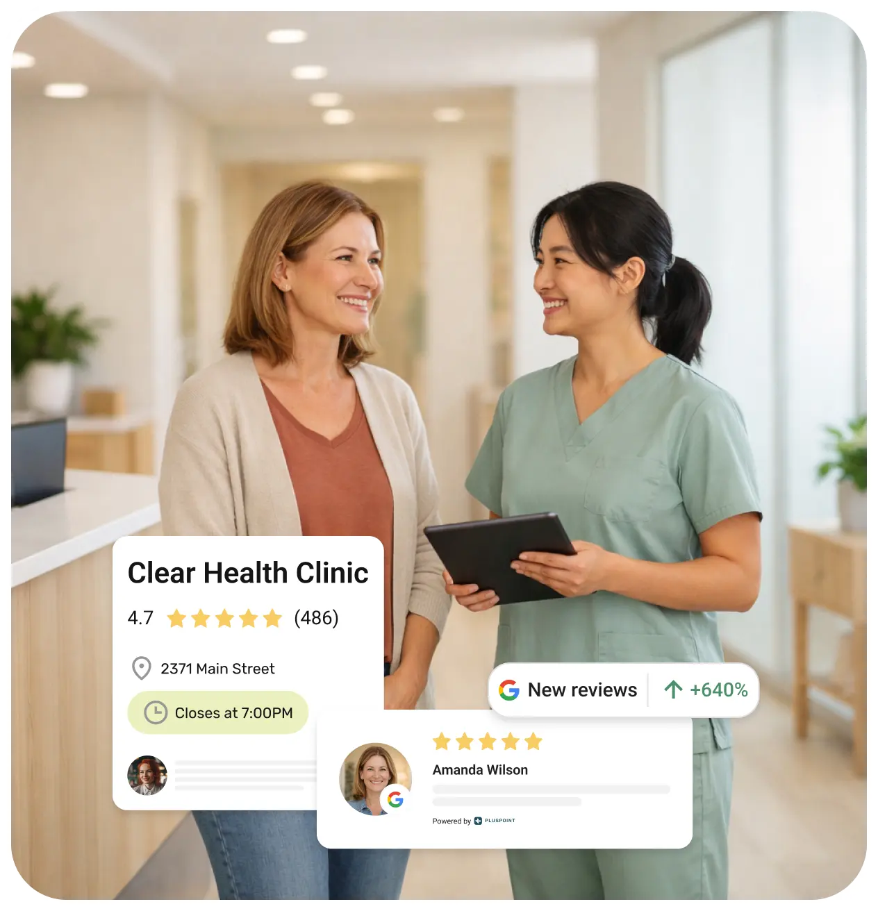 Smiling female healthcare worker in scrubs holding a tablet talks with a woman in a clinic reception area.