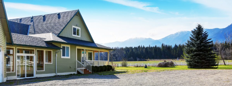 Rural home with a gravel driveway, fenced paddock and mountain views