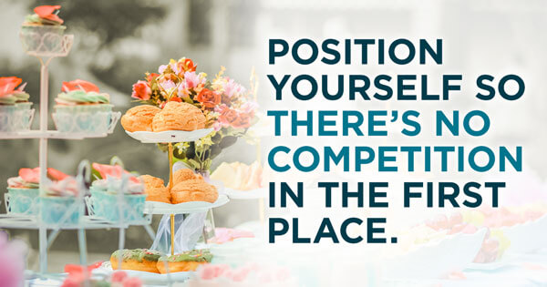 A table with a catering tower set up containing pasties, donuts, cupcakes, fruit, and a floral arrangement. The overlay of words reads, "Position yourself so there's no competition in the first place."