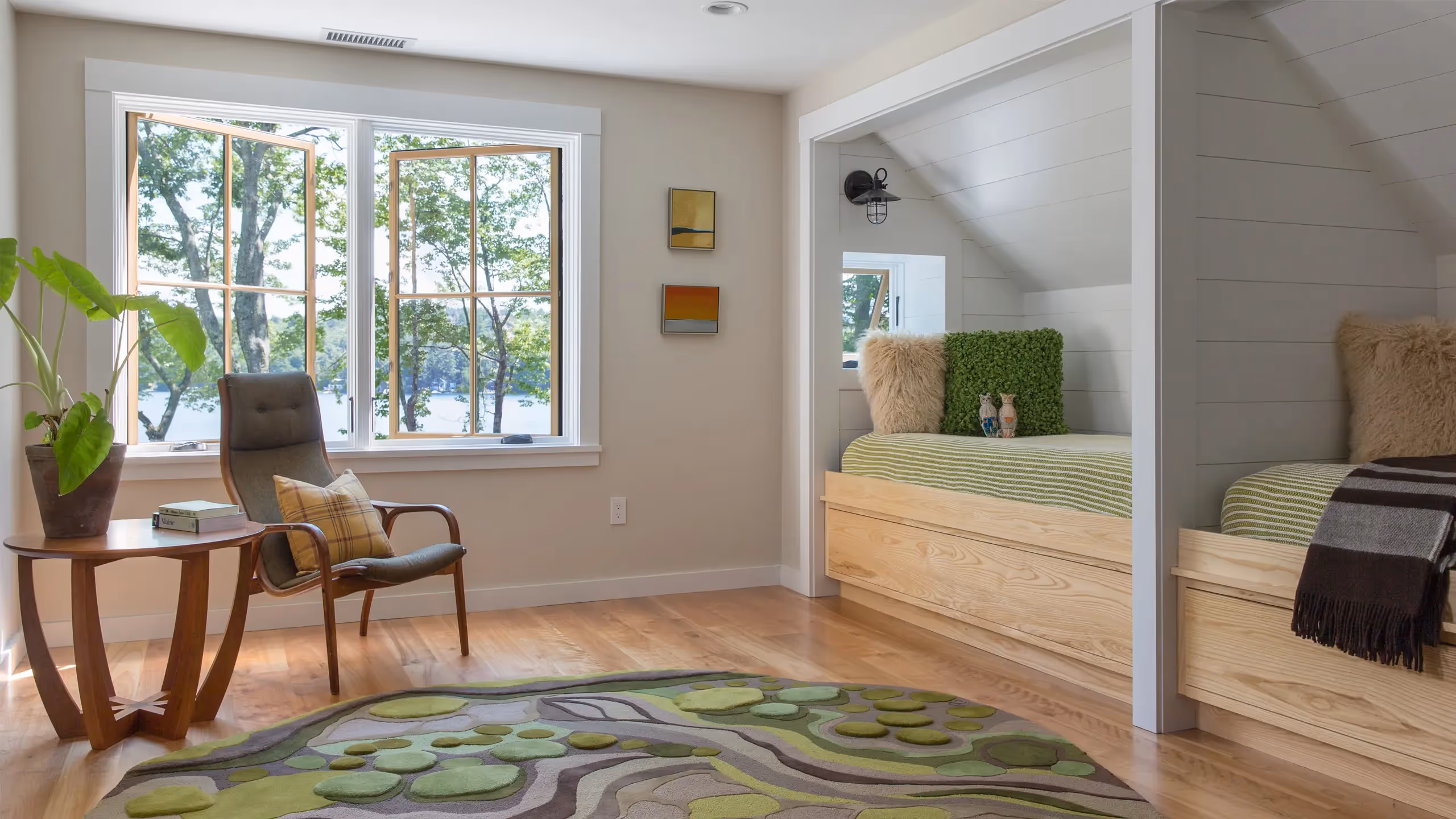Cozy bedroom with large windows, wooden bed, chair, and nature-inspired rug