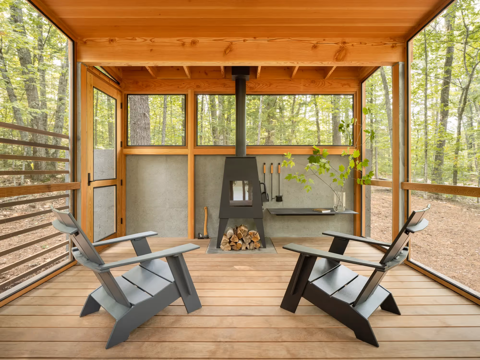 Modern wood cabin interior with geometric chairs and wood stove