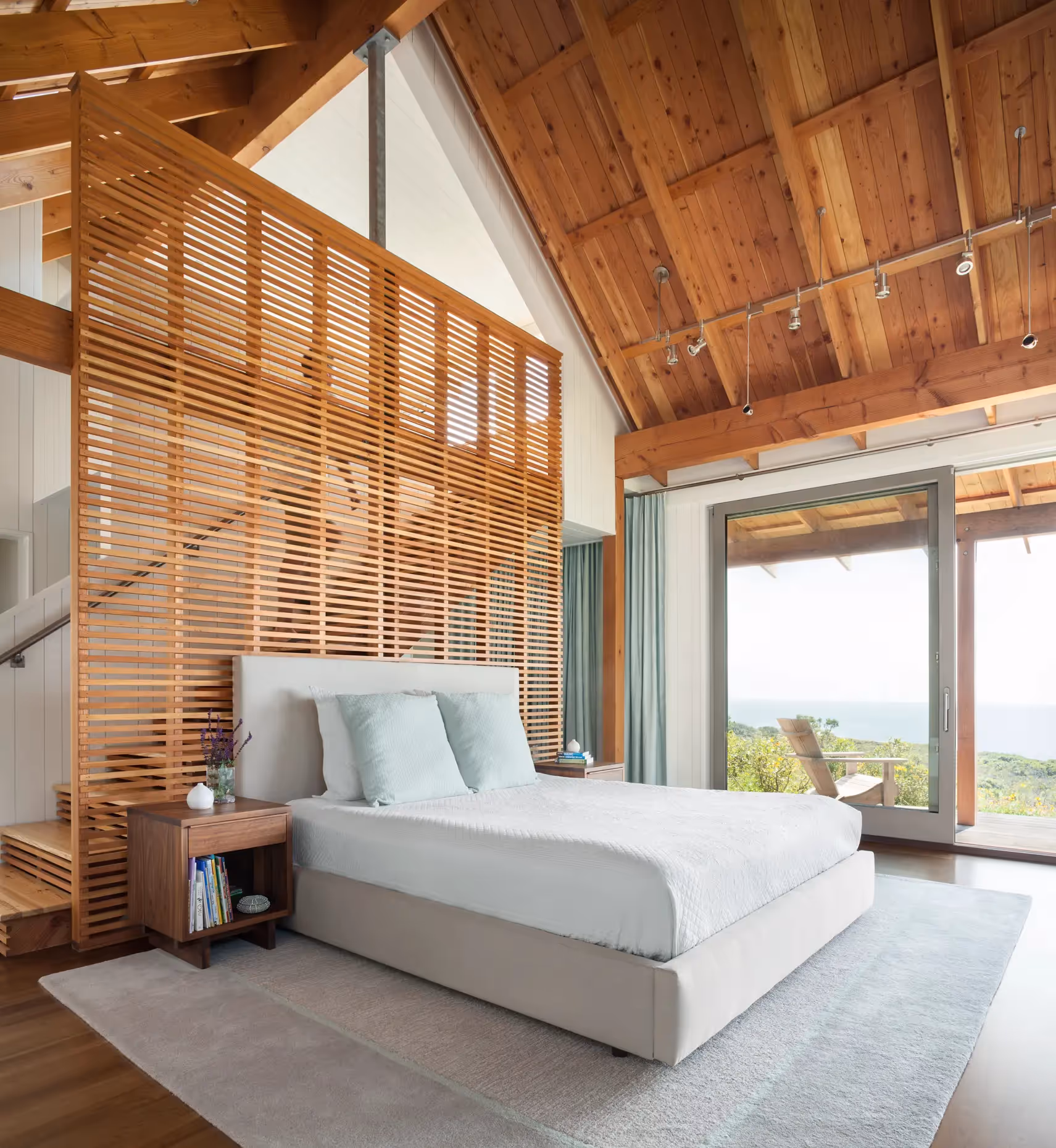 Modern wooden bedroom with ocean view and slatted wood wall