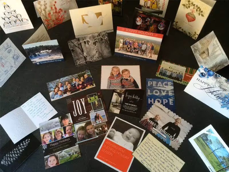 Assorted holiday and greeting cards spread out on a dark background