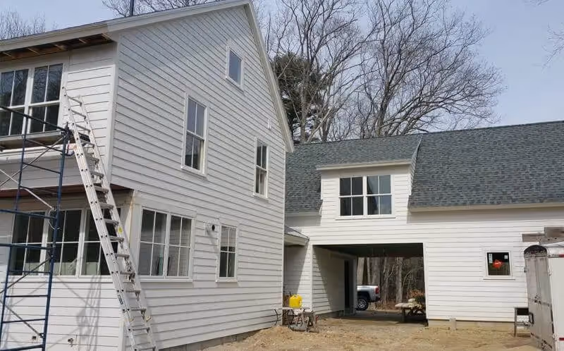 White house under construction with scaffolding and ladder