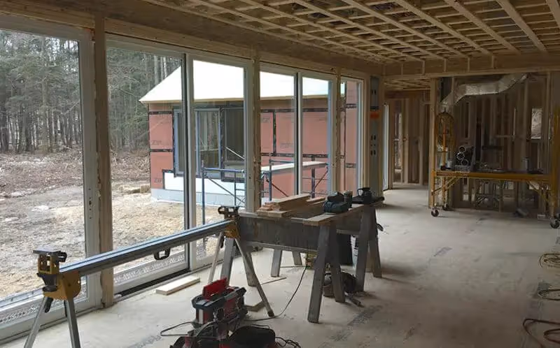 Interior of house under construction with large windows and building materials