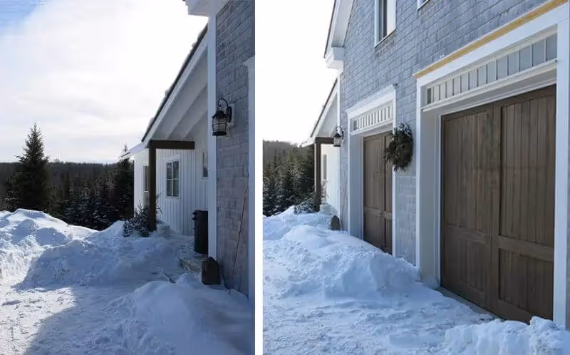 Snowy winter scene of a house with wooden garage doors and deep snow