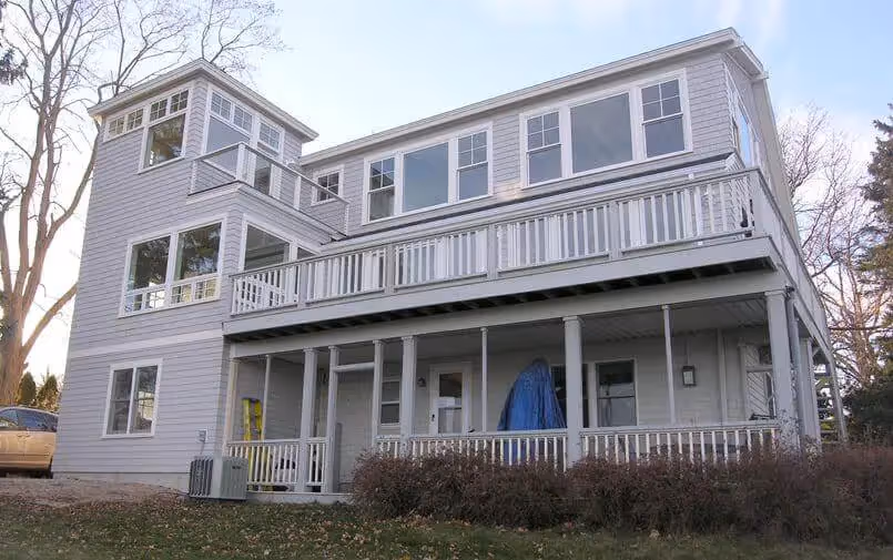 White two-story house with multiple decks and large windows