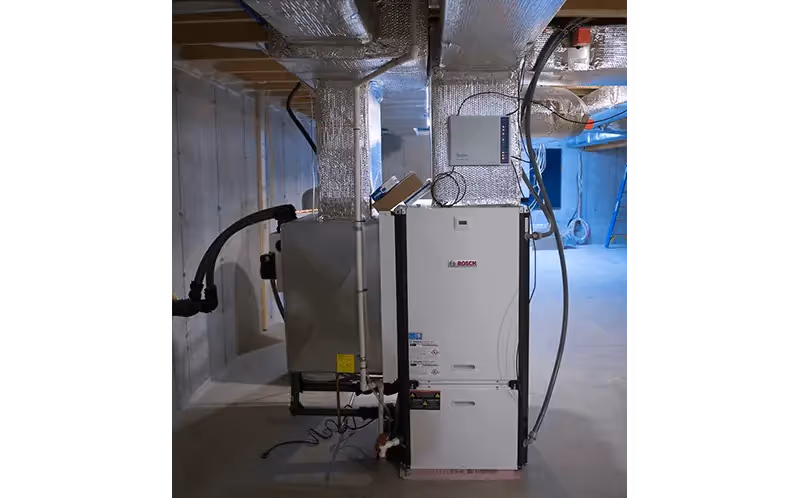 Bosch heating system installed in basement with insulated pipes and wiring