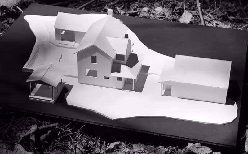 Architectural white scale model of a multi-building house on uneven terrain