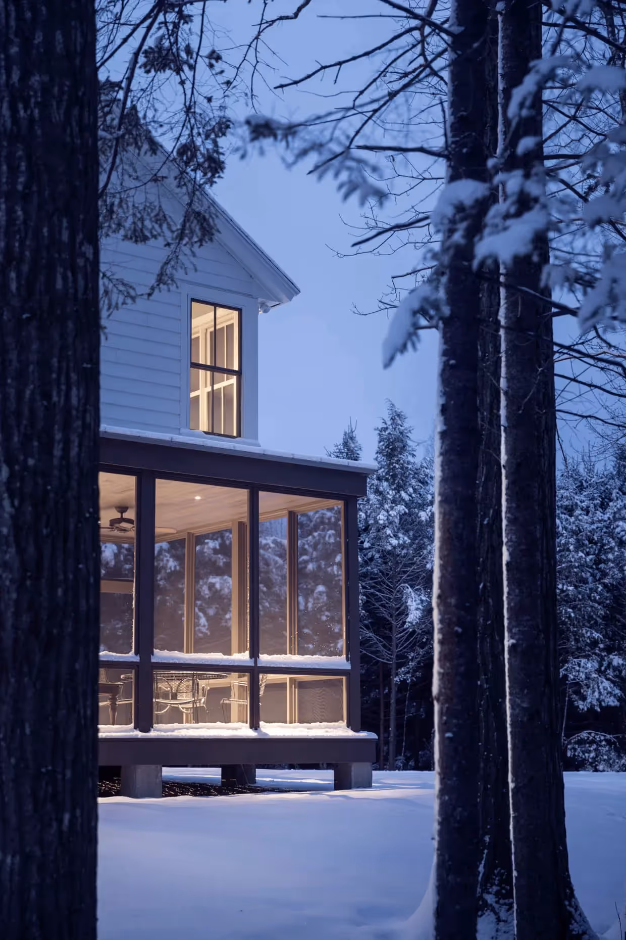 Cozy winter cabin with warm lights nestled among snow-covered trees